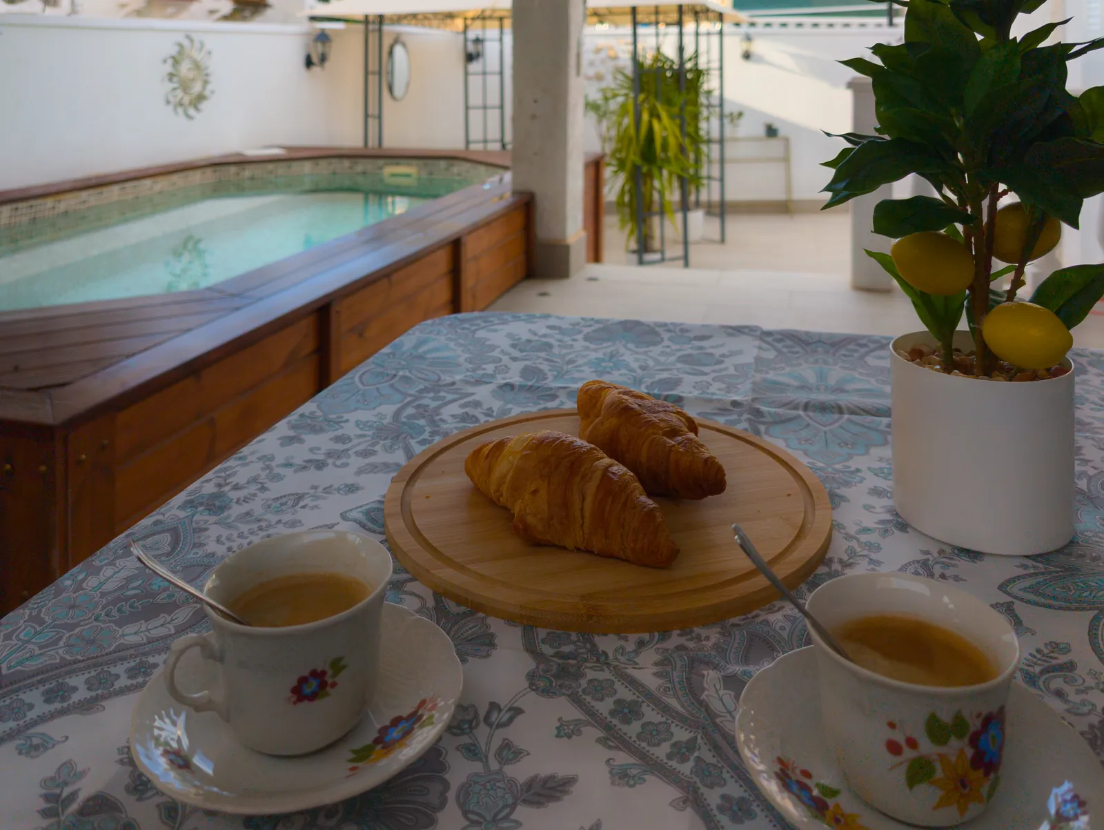 Coffee and croissants on a table beside the pool